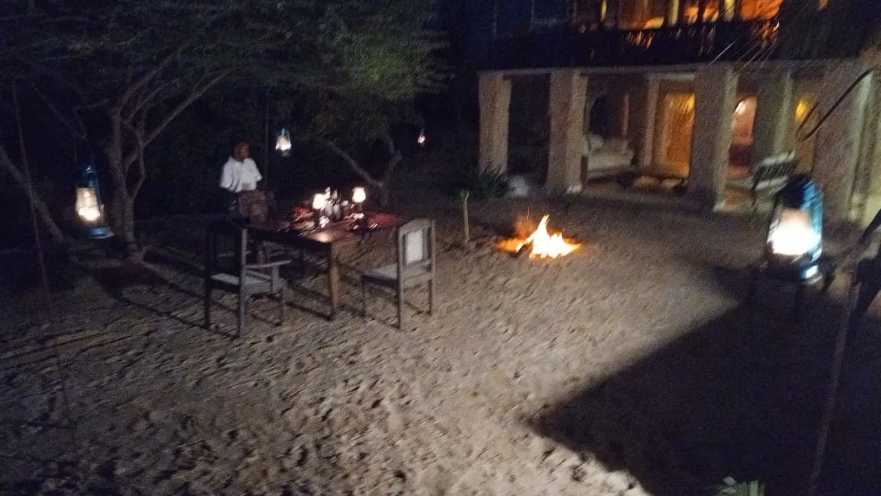 Private beach dining with bonfire setup