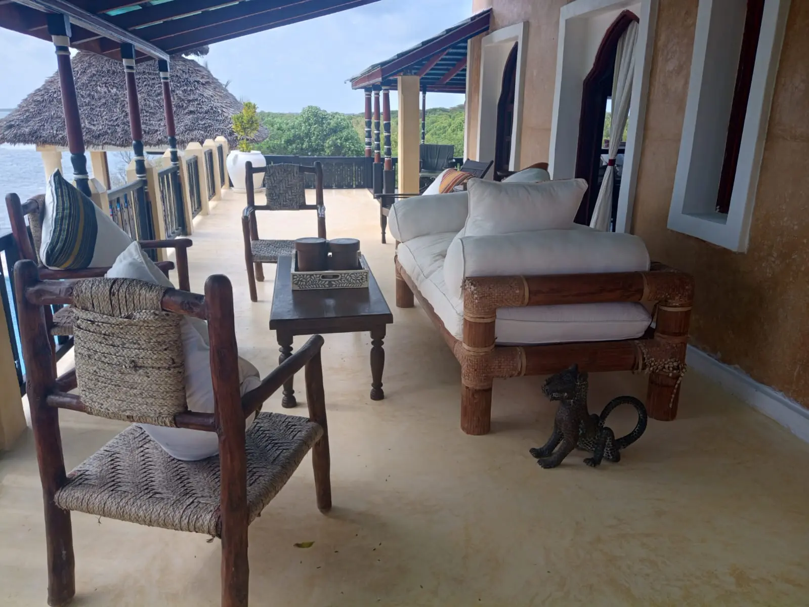 Covered terrace with traditional woven furniture and ocean views
