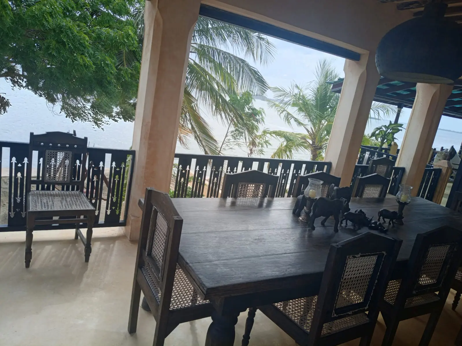 Formal dining area with large wooden table and tropical garden views