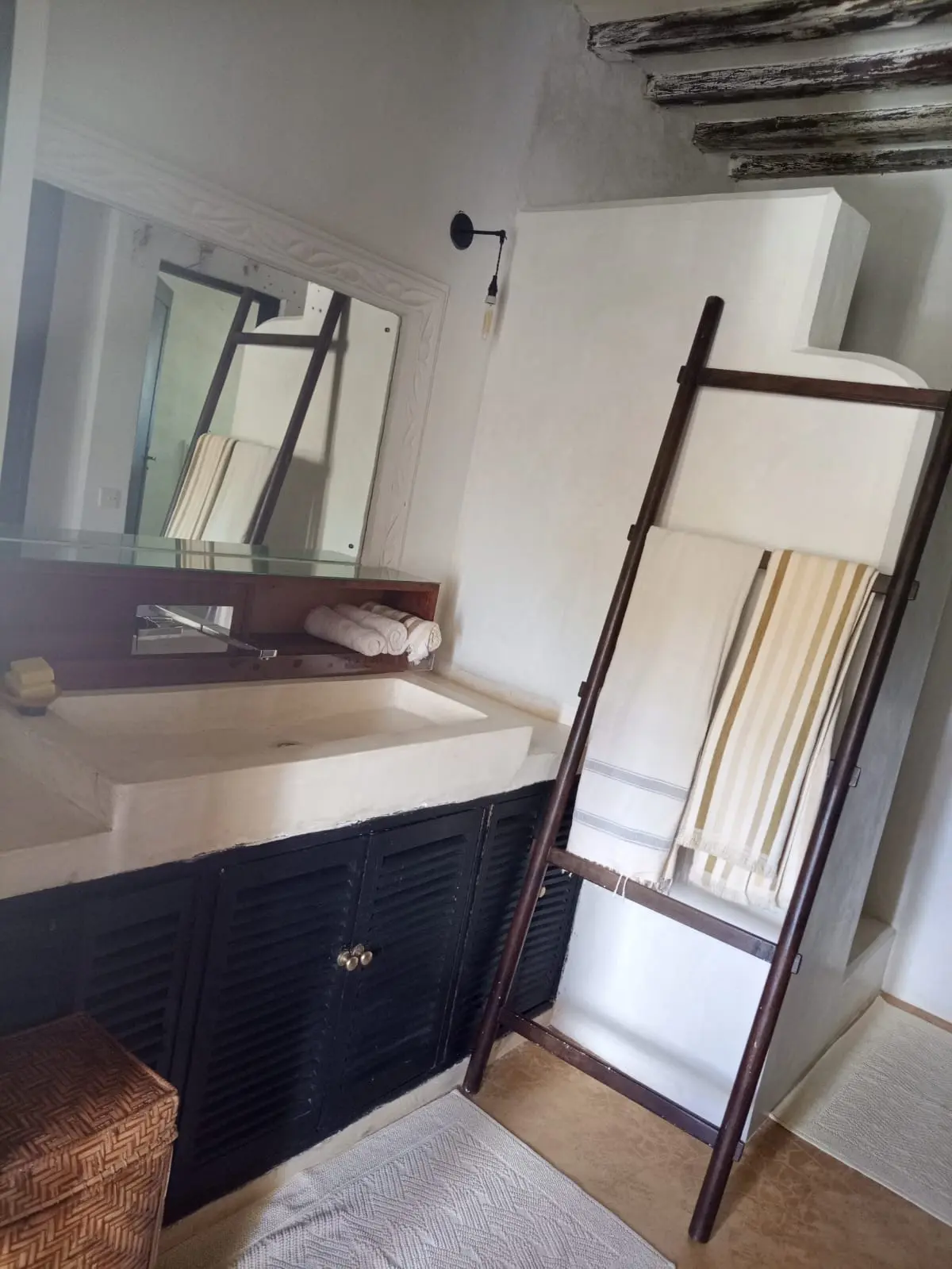 Modern bathroom with stone sink and traditional wooden ladder