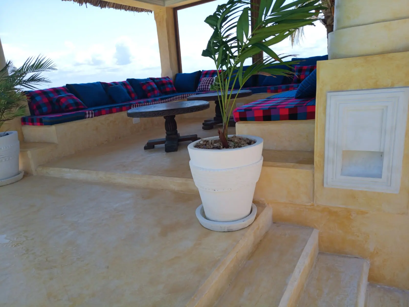 Pool terrace seating area with blue cushions and traditional table